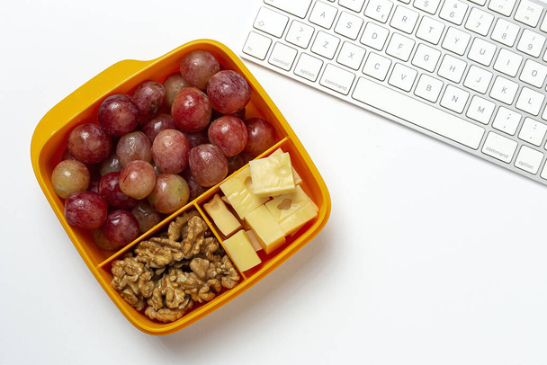 Healthy Food in Plastic containers ready to eat with Cheese, grapes and walnuts on the work table. To take away.walnuts. Isolated - Foto, afbeelding