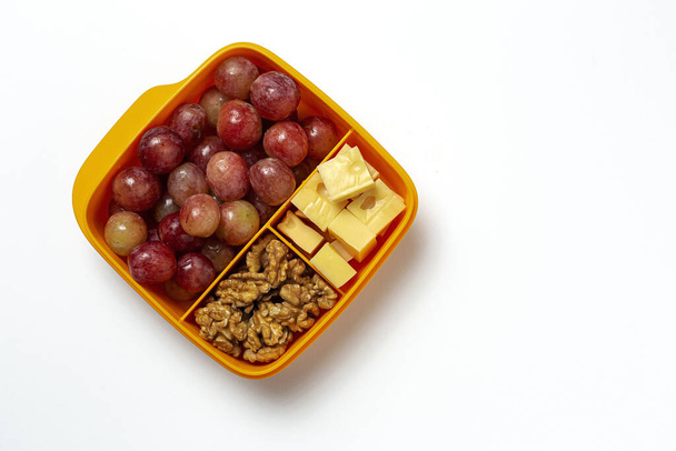 Healthy Food in Plastic containers ready to eat with Cheese, grapes and walnuts on the work table. To take away.walnuts. Isolated - Fotografie, Obrázek