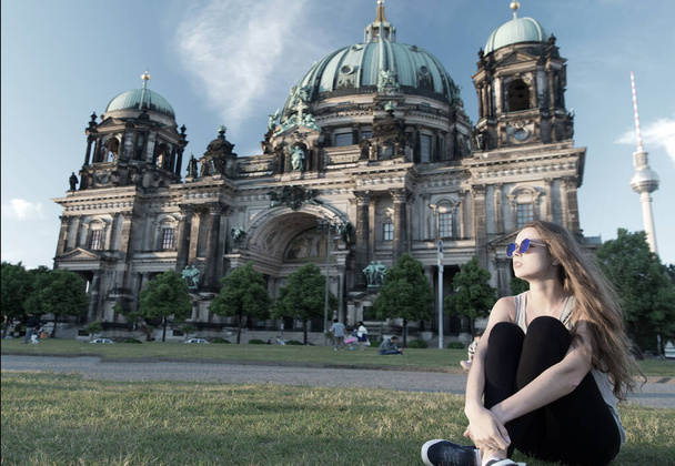 thoughtful girl tourist sitting in germany near berlin cathedral. berlin cathedral view in germany with sitting girl. building tomorrow world today. travel around europe. life is awesome. - Foto, immagini