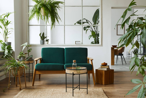 Stylish scandinavian living room interior with green velvet sofa, coffee table, carpet, plants, furniture, elegant accessories in modern home decor. Template. - Фото, изображение