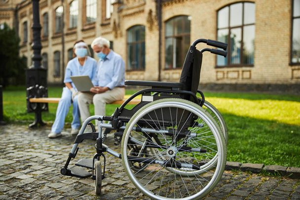 Γέρο συνταξιούχο piου κάθεται κοντά σε νοσοκόο στον πάγκο - Φωτογραφία, εικόνα