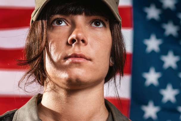 アメリカのお祝い。アメリカの国旗を背景にした女性兵士の肖像画. - 写真・画像