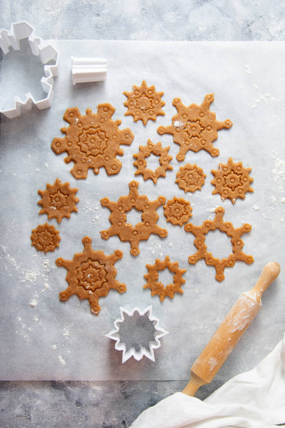 Christmas baking cookies snowflakes shape. Raw dough, cookie cutters, rolling pin. Abstract winter food background. - Фото, зображення