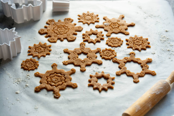 Christmas baking cookies snowflakes shape. Raw dough, cookie cutters, rolling pin. Abstract winter food background. - Fotó, kép