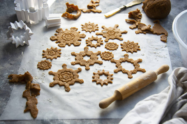 Christmas baking cookies snowflakes shape. Raw dough, cookie cutters, rolling pin. Abstract winter food background. - Foto, afbeelding