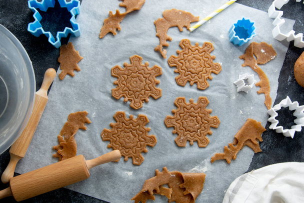 Christmas baking cookies snowflakes shape. Raw dough, cookie cutters, rolling pin. Abstract winter food background. - Foto, immagini