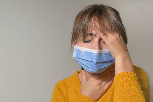 Женщина в медицинской защитной маске и при боли в горле - Фото, изображение