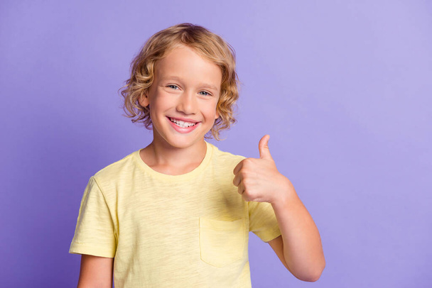 Photo of positive kid small boy show thumb up sign wear casual style clothes isolated over violet color background - Foto, Imagen