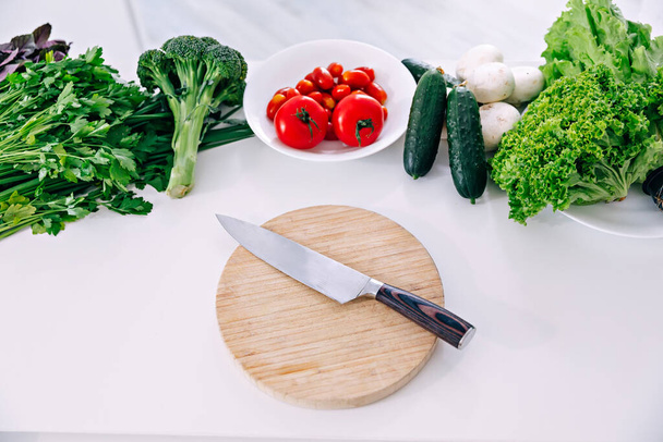 Νόστιμα ποικιλία από φρέσκα λαχανικά του αγροκτήματος με μαχαίρι σε ξύλινη σανίδα, top view. - Φωτογραφία, εικόνα