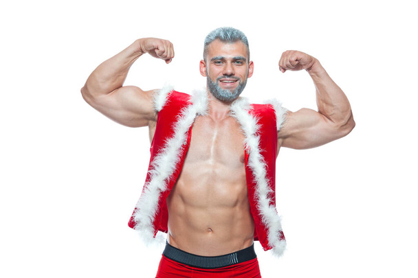 Sexy Santa Claus . Young muscular man wearing Santa Claus hat demonstrate his muscles. Isolated on white background. - Foto, immagini