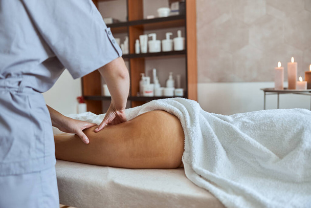 Young atractive female in massage salon is having beauty and healthcare procedures - Foto, imagen