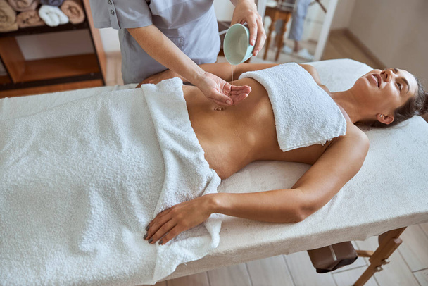 Giovane femmina atractive nel salone di massaggio sta avendo procedure di bellezza e assistenza sanitaria - Foto, immagini