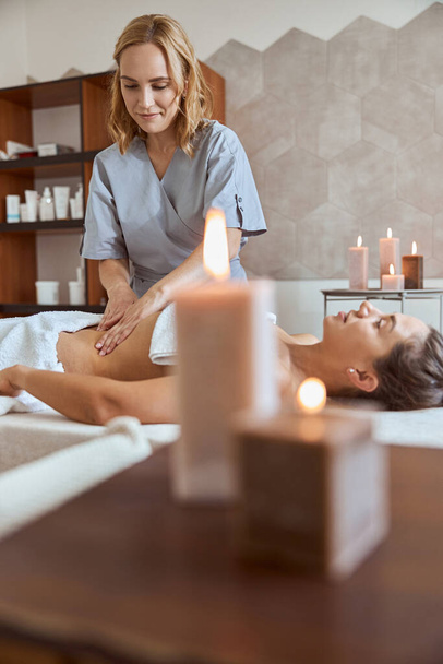 Young atractive female in massage salon is having beauty and healthcare procedures - Фото, зображення