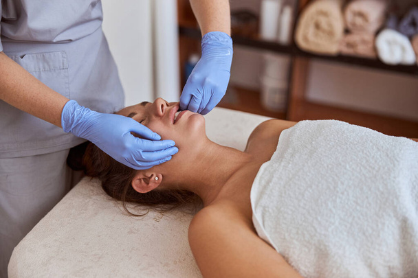 Mladá atraktivní žena v masážním salonu má kosmetické a zdravotnické procedury - Fotografie, Obrázek