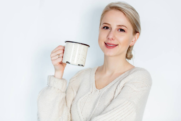 Blondýny dívka ve svetru s hrnkem na bílém pozadí  - Fotografie, Obrázek