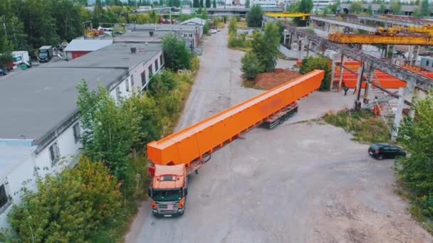 Перевозка оранжевых частей подъемных кранов на грузовике с завода - Кадры, видео