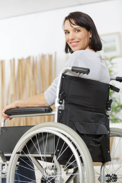 happy woman in a wheelchair at home - Foto, Bild