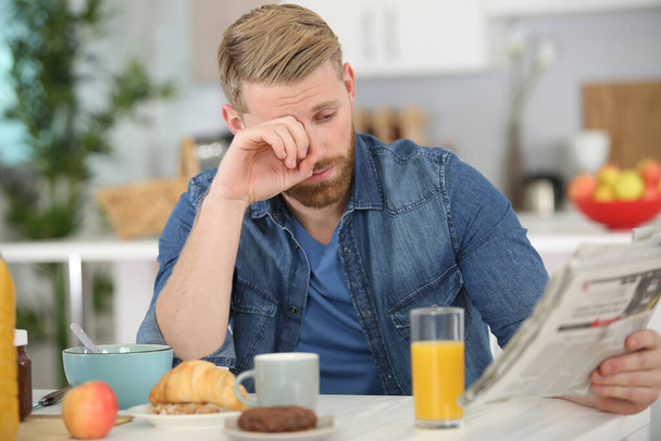 man is upset reading the newspaper at breakfast time - Photo, image