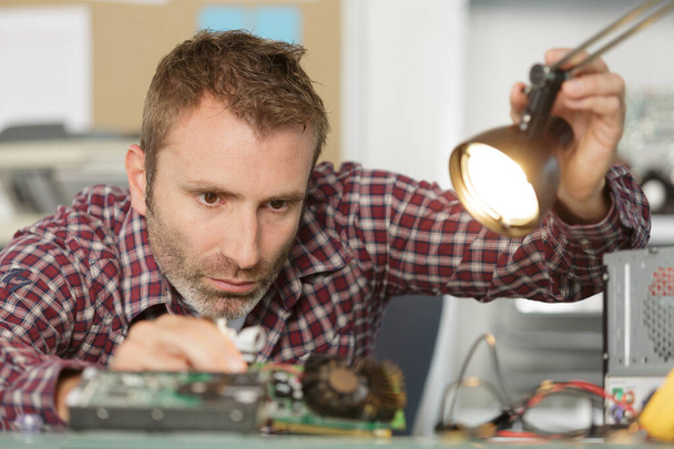 concentrated man fixing electronics - Zdjęcie, obraz