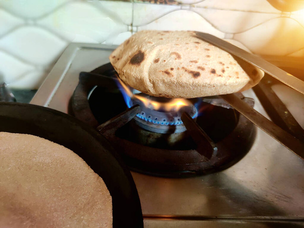 Tradycyjny sposób robienia indyjskiego Roti Chapati Tava Roti, w indyjskim gospodarstwie domowym. Kolacja, ciasto. Słowa kluczowe: indian, chapati, roti, traditional - Zdjęcie, obraz
