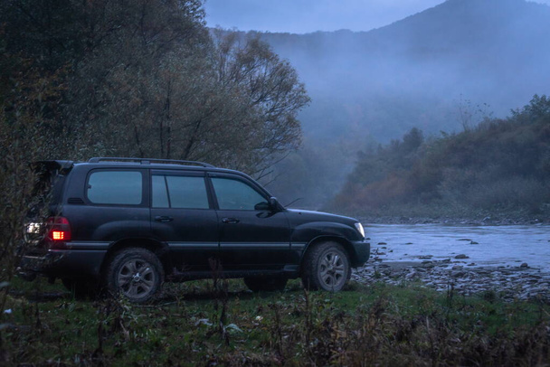 SUV en un río de montaña en la niebla - Foto, imagen