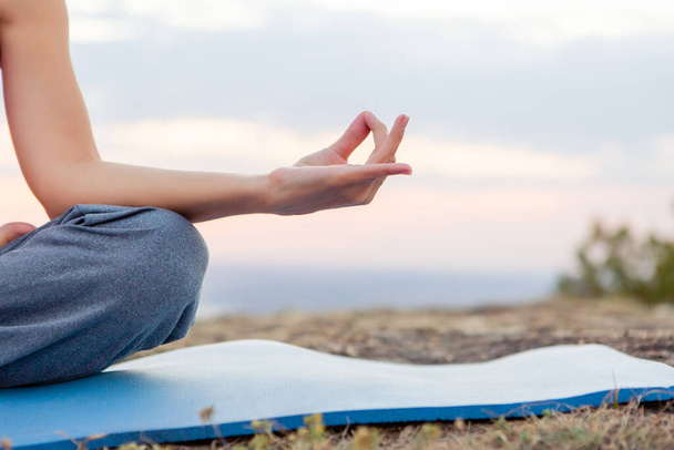 giovane donna incinta che pratica yoga all'aperto. Yoga al tramonto - Foto, immagini
