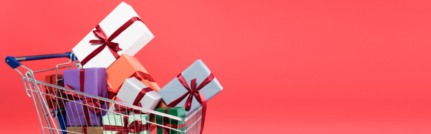 Presents with bows in shopping cart isolated on red, banner - Fotografie, Obrázek