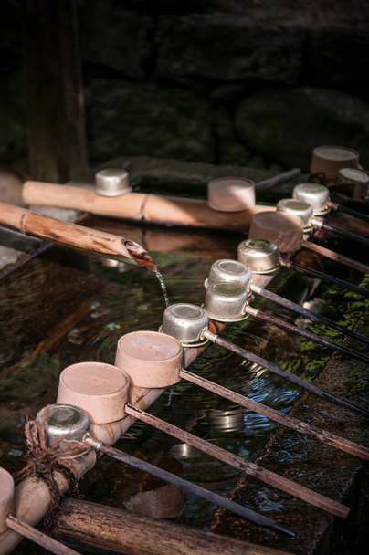 Chozusha - Traditionelle kleine Wanne mit Wasserdippern zur Körperreinigung vor dem Betreten des japanischen Schreins - Foto, Bild