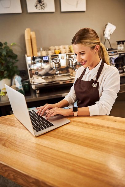 Kafe 'nin beyaz kadın yönetimi bilgisayar ekranına bakıyor. - Fotoğraf, Görsel