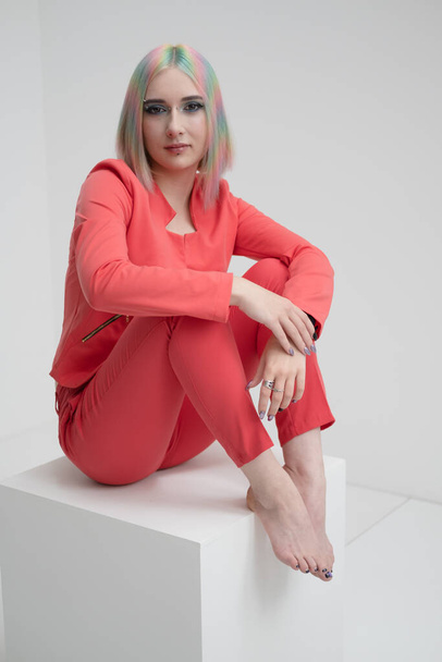 Portrait of a young beautiful informal blonde girl with dyed hair. Red jacket suit on the naked body. Studio photoshoot on a white background. - Φωτογραφία, εικόνα