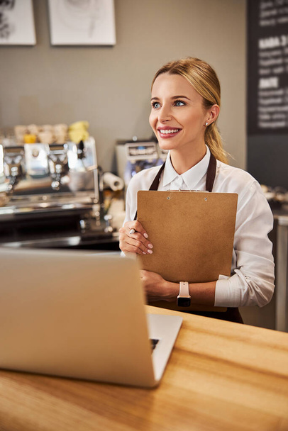 Young Caucasian woman in uniform in the coffee bar - Photo, image