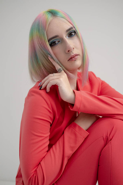 Portrait of a young beautiful informal blonde girl with dyed hair. Red jacket suit on the naked body. Studio photoshoot on a white background. - Zdjęcie, obraz