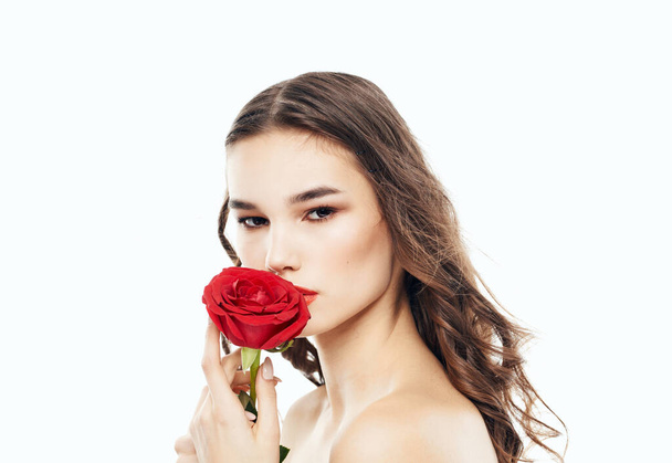 Charmante femme peau propre cosmétologie maquillage lumineux et fleur rouge - Photo, image