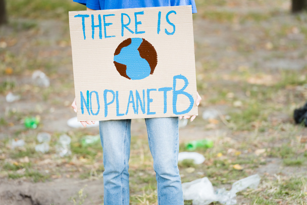 Ausgeschnittene Ansicht von Freiwilligen mit Plakat mit Globus und es gibt keine Planet b-Inschrift, Ökologie-Konzept - Foto, Bild