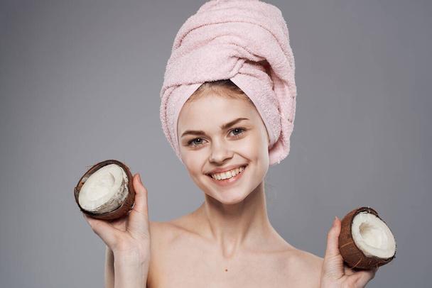 Χαρούμενη γυναίκα με καρύδες στα χέρια γυμνή ώμους φυσική θεραπεία καλλυντικών φροντίδα του δέρματος - Φωτογραφία, εικόνα