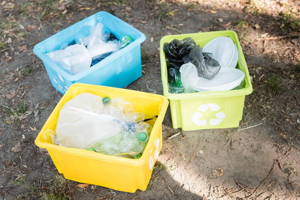 műanyag hulladékkal teli tárolóedények újrahasznosító szimbólumokkal, ökológia koncepció - Fotó, kép
