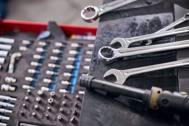 Auto-Reparatursatz und Schraubenschlüssel an der Kfz-Werkstatt - Foto, Bild