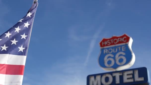 Tarihi güzergah 66 'daki motelin retro tabelası Amerika' nın klasik yol gezisi sembolü. Arizona çölünde ikonik pano. Eski moda neon tabela. Ulusal bayrak dalgalanması - Video, Çekim