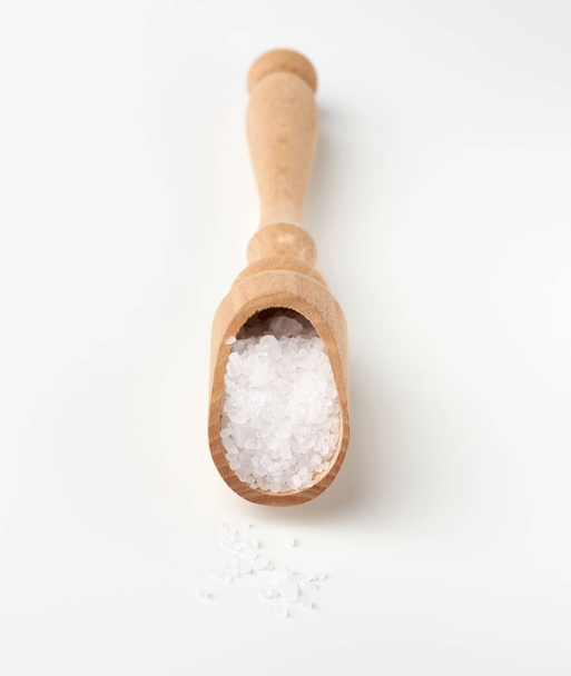 large crystals of white sea salt in a brown wooden spoon, top view - Photo, Image