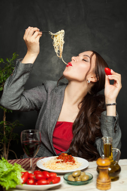 Pretty woman eating italian pasta spaghetti in restaurant - Foto, Bild