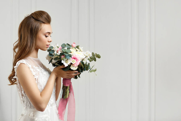 beautiful tender young bride with flower bouquet - Fotografie, Obrázek