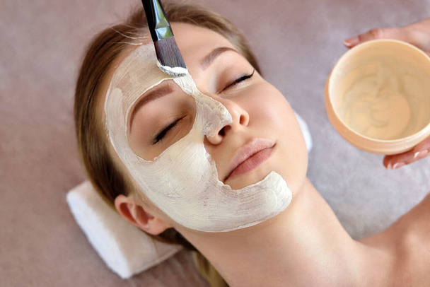 Ace Peeling Maske, Wellness-Beauty-Behandlung, Hautpflege. Frau bekommt Gesichtspflege von Kosmetikerin im Wellness-Salon, Nahaufnahme - Foto, Bild