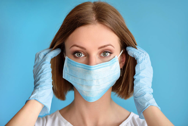 Girl puts a medical face mask for protection against infection. Healthcare and medical concept. - Фото, изображение