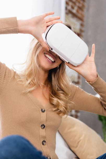 Iloinen nainen käyttää virtuaalitodellisuus kuulokkeet kotona  - Valokuva, kuva