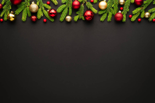 Zwarte kerst achtergrond met sierlijke frame van kerstboom decoraties. Top view met kopieerruimte voor feestelijke vakantietekst - Foto, afbeelding