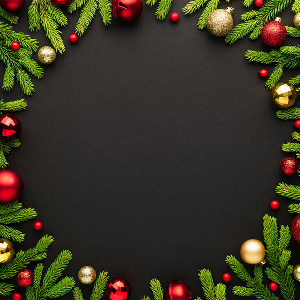 Nieuwjaar en kerst zwarte achtergrond met sparren frame. Kopieer ruimte voor reclametekst. Bovenaanzicht van een kaart met decoraties - Foto, afbeelding