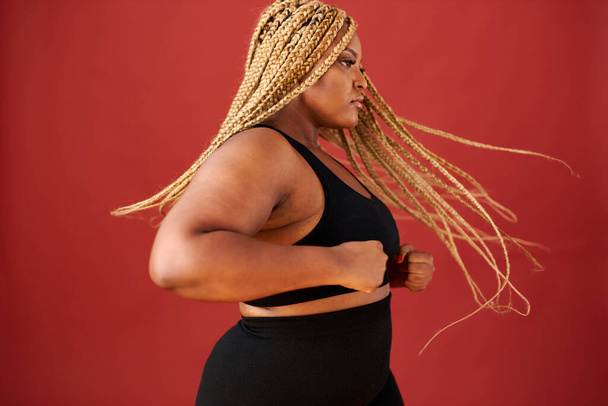 side view on african american overweight woman in action - 写真・画像