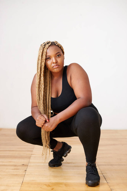 plump, plus size african american woman in sportswear posing in studio - Фото, зображення