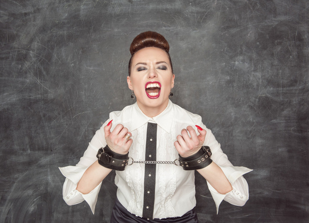 Screaming business woman with handcuffs on her hands - Photo, Image