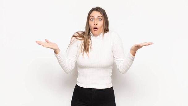 young blonde woman feeling extremely shocked and surprised, anxious and panicking, with a stressed and horrified look - 写真・画像